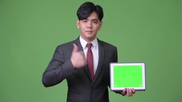 Young handsome Asian businessman using digital tablet — Stock Video