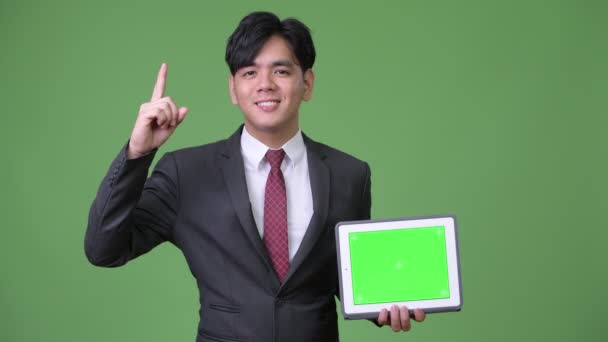 Young handsome Asian businessman using digital tablet — Stock Video