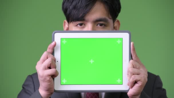Молодой привлекательный азиатский бизнесмен использует цифровой планшет — стоковое видео