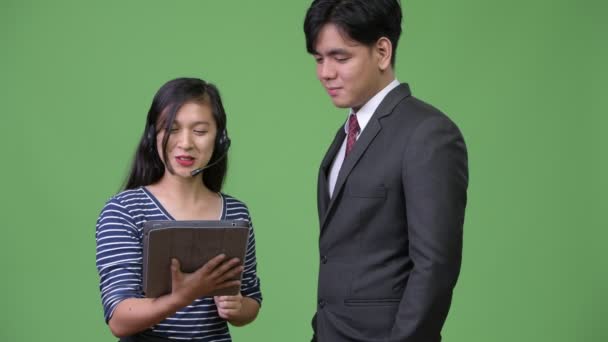 Young handsome Asian businessman and young Asian woman working together — Stock Video