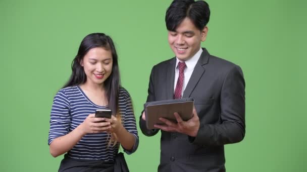 Junge hübsche asiatische Geschäftsmann und junge asiatische Frau arbeiten zusammen — Stockvideo