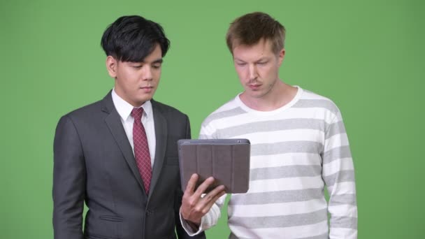 Jovem bonito empresário asiático e jovem empresário escandinavo trabalhando juntos — Vídeo de Stock