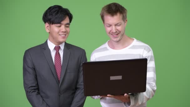 Ung Vacker asiatisk affärsman och unga skandinaviska affärsman som arbetar tillsammans — Stockvideo