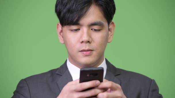 Mladý pohledný asijský podnikatel pomocí mobilního telefonu — Stock video