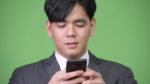 Cep telefonu kullaranarak genç yakışıklı Asya iş adamı — Stok video