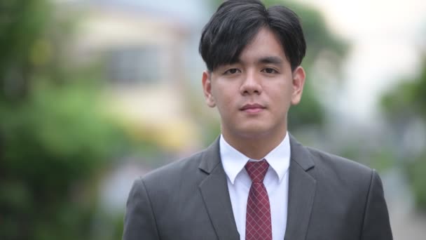 屋外の路上で若いハンサムなアジア系のビジネスマン — ストック動画