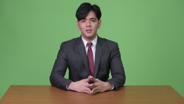 Νέος όμορφος Ασίας επιχειρηματίας ενάντια σε πράσινο φόντο — Αρχείο Βίντεο