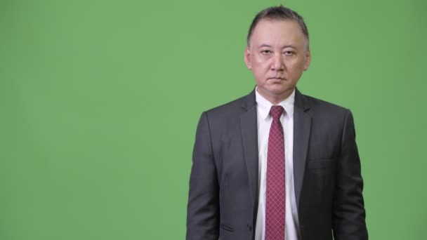 Rijpe Japanse zakenman tonen iets — Stockvideo