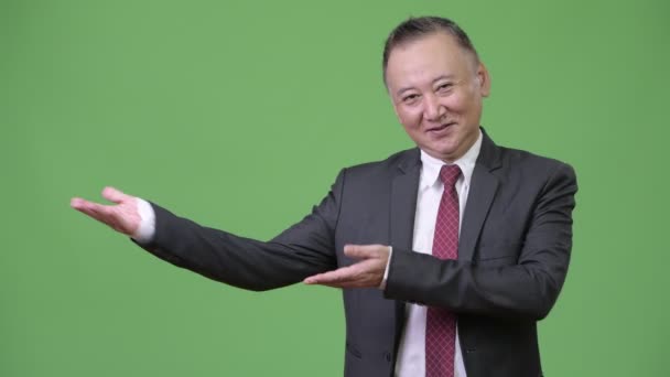 Mature homme d'affaires japonais montrant quelque chose — Video