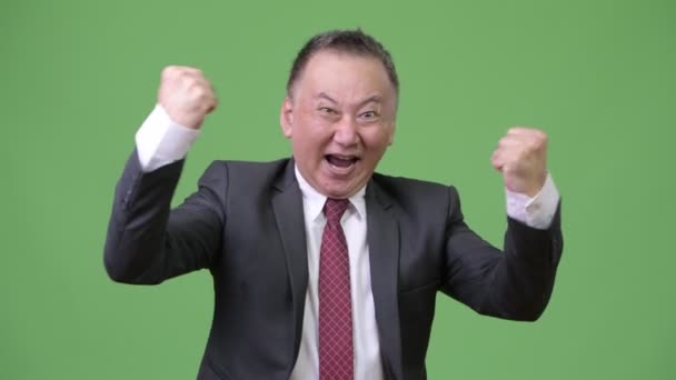 Зрілі щасливим японського бізнесмен посміхатися і відчуває себе схвильований — стокове відео