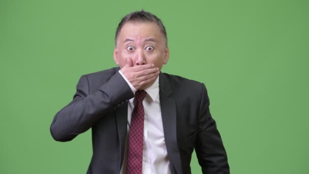Mogna japansk affärsman som täcker munnen och ser skyldig — Stockvideo