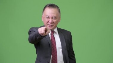 Olgun kızgın Japon işadamı kameraya işaret