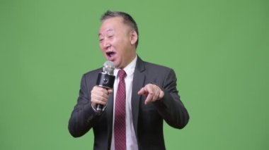 Olgun Japon işadamı mikrofon kullanarak