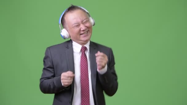 Reife japanische Geschäftsmann Musik hören — Stockvideo