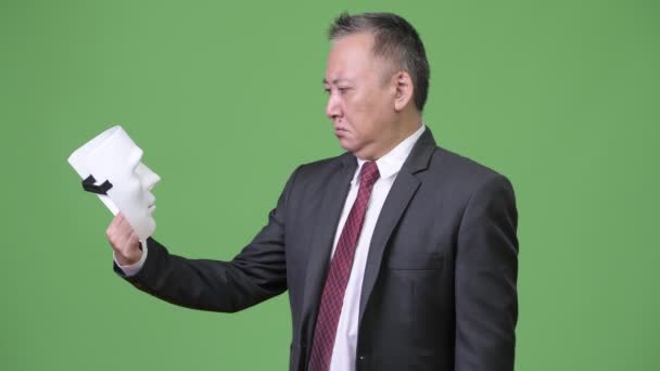 Dojrzały japoński biznesmen z białą maskę jako koncepcja — Wideo stockowe
