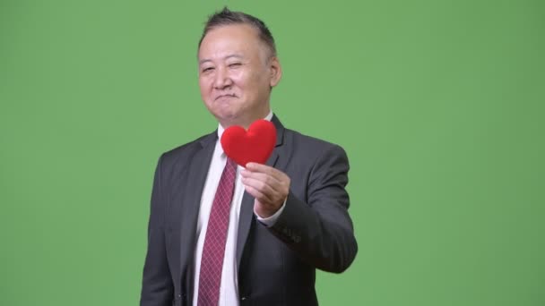 Olgun Japon işadamı kırmızı kalp Sevgililer günü için hazır tutuyor — Stok video
