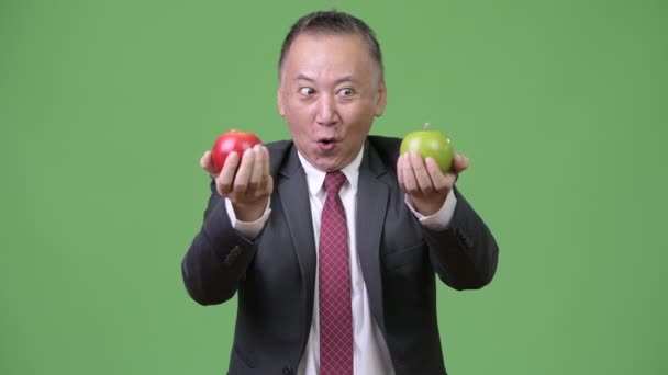 Ώριμη ιαπωνική επιχειρηματίας με μήλα — Αρχείο Βίντεο
