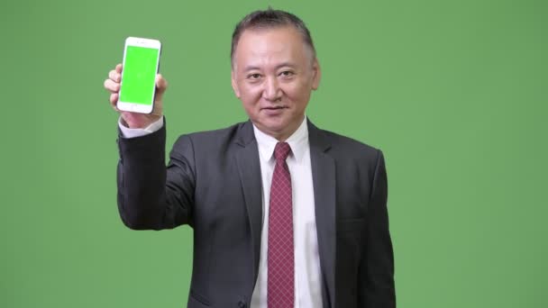 Mature japonais homme d'affaires montrant téléphone à la caméra — Video