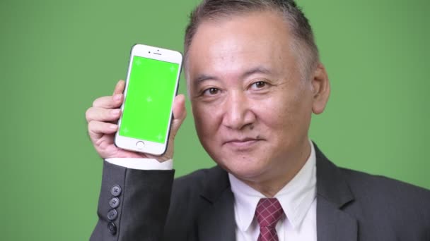 Ώριμη ιαπωνικός επιχειρηματίας δείχνει τηλέφωνο με φωτογραφική μηχανή — Αρχείο Βίντεο