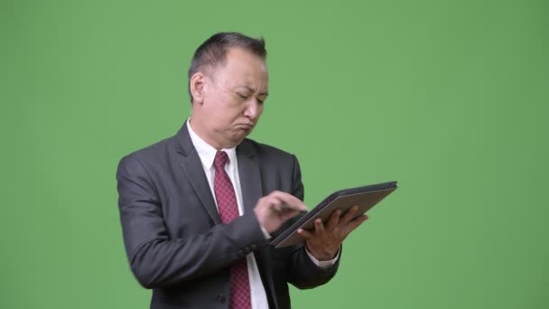 Dojrzały japoński biznesmen, pracę z cyfrowego tabletu — Wideo stockowe