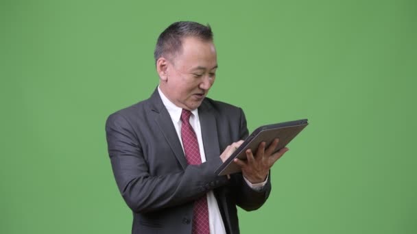 Rijpe Japanse zakenman werken met digitale tablet — Stockvideo