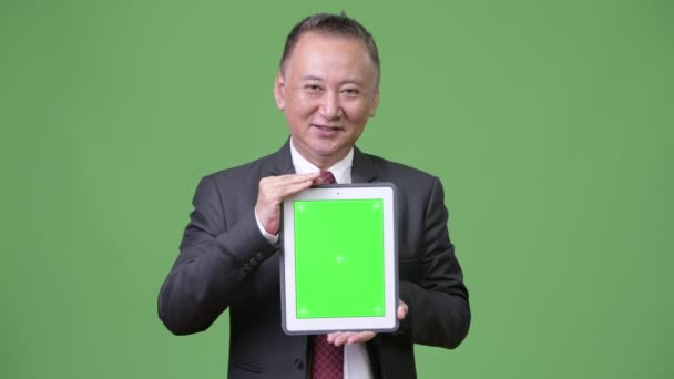 Mature Japanese businessman showing digital tablet — Stock Video