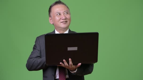 Mature Japanese businessman working with laptop — Stock Video