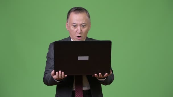 Mature Japanese businessman working with laptop — Stock Video