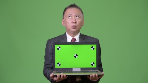 Ώριμη ιαπωνικός επιχειρηματίας που δείχνει το laptop — Αρχείο Βίντεο