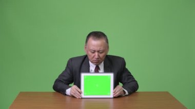 Olgun Japon işadamı gösteren dijital tablet