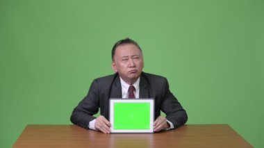Olgun Japon işadamı gösteren dijital tablet