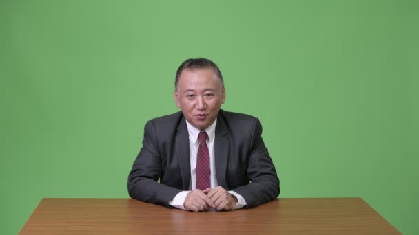 Ώριμη ιαπωνικός επιχειρηματίας που δείχνουν κάτι — Αρχείο Βίντεο