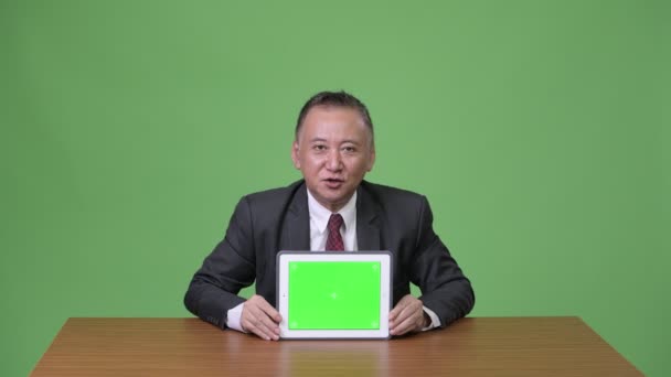 Ώριμη ιαπωνική επιχειρηματίας δείχνει ψηφιακή δισκίο — Αρχείο Βίντεο