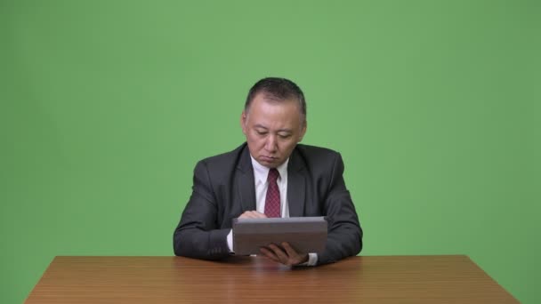 Ώριμη ιαπωνικός επιχειρηματίας που εργάζεται με ψηφιακό tablet — Αρχείο Βίντεο