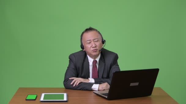 Ώριμη ιαπωνικός επιχειρηματίας που εργάζεται ως εκπρόσωπος του κέντρου κλήσεων — Αρχείο Βίντεο