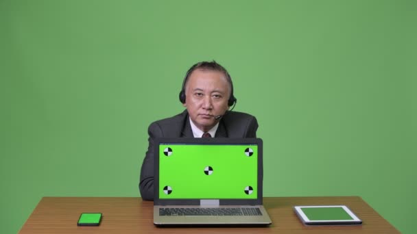 Rijpe Japanse zakenman, werkzaam als call center vertegenwoordiger — Stockvideo