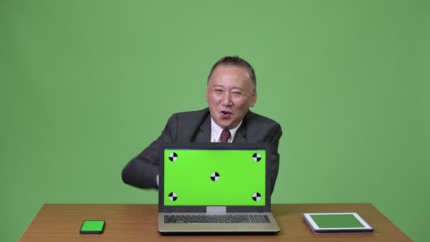 Rijpe Japanse zakenman werken met laptop — Stockvideo