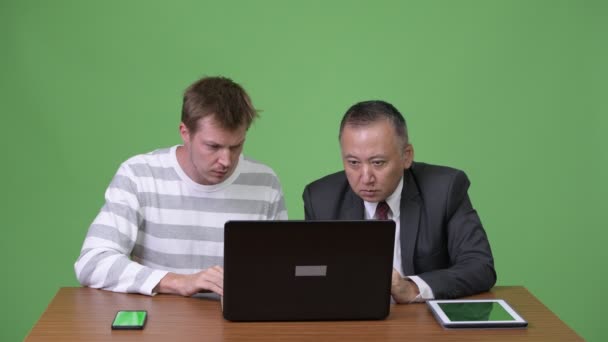 Mature Japanese businessman and young Scandinavian businessman working together — Stock Video