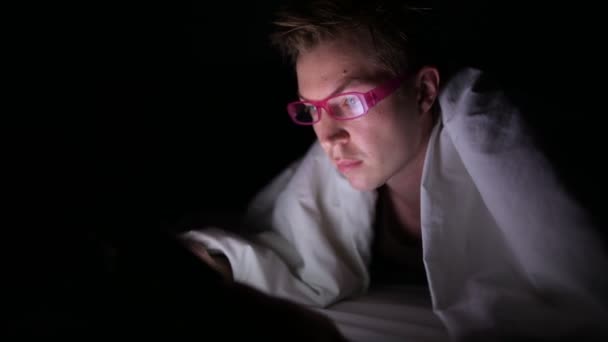 Jovem homem escandinavo bonito usando tablet digital no quarto escuro — Vídeo de Stock