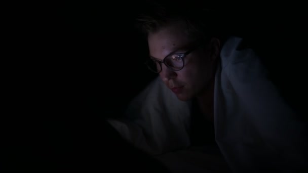 Joven hombre escandinavo guapo usando tableta digital en habitación oscura — Vídeo de stock