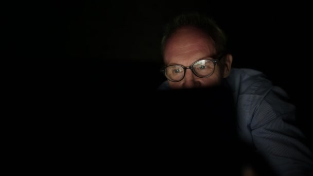 Uomo scandinavo maturo che guarda video per adulti con tablet digitale in camera oscura — Video Stock