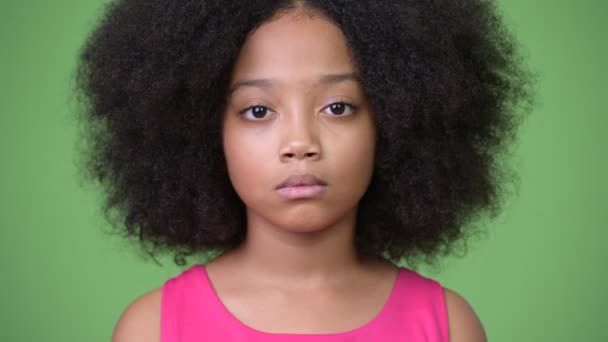 Young cute African girl with Afro hair against green background — Stock Video