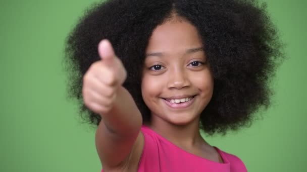 Jeune fille africaine mignonne avec des cheveux afro donnant pouces vers le haut — Video