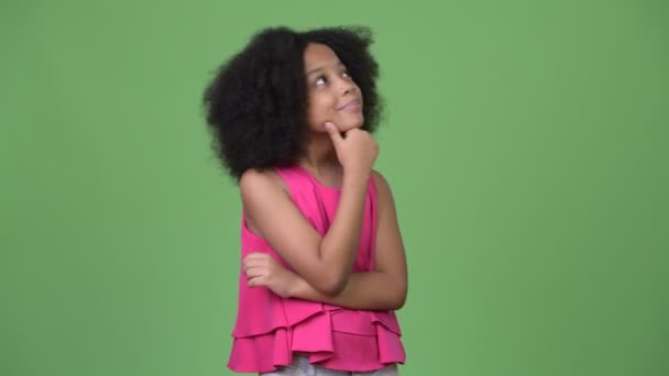 Junges süßes afrikanisches Mädchen mit Afro-Haaren lächelt beim Nachdenken — Stockvideo