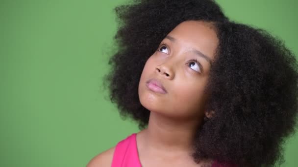 Jovem menina africana bonito com cabelo afro pensando enquanto olha para cima — Vídeo de Stock