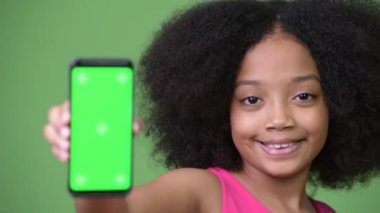 Telefon gösterilen Afro saçlı Genç Sevimli Afrikalı kız