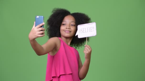 Молоді милі дівчата, які Африканського, афро волосся, беручи selfie з паперу знак — стокове відео