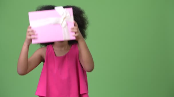 Mladý roztomilý Africká dívka s Afro vlasy drží krabičky — Stock video