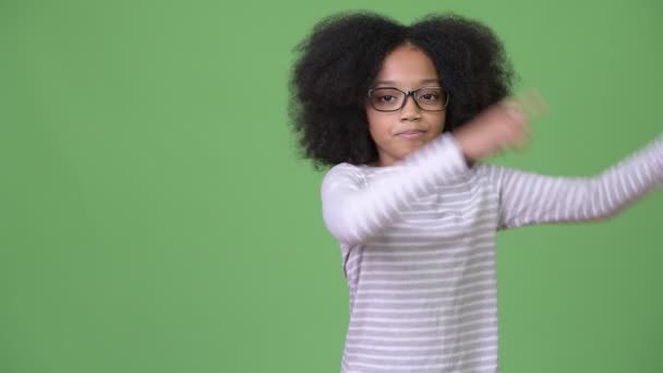 Νέοι χαριτωμένο Αφρικανική κορίτσι με αφρο μαλλιά δείχνουν κάτι — Αρχείο Βίντεο