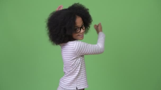 Jonge schattige Afrikaanse meisje met Afro haar iets tonen — Stockvideo